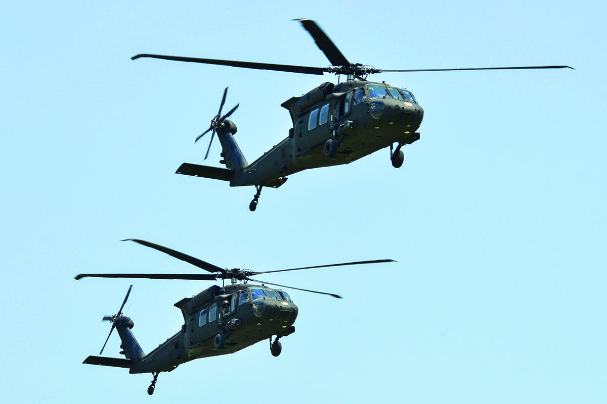 Two U.S. Army UH-60 Black Hawk helicopters assigned to the 101st Airborne Division fly over the parade field during a pass and review ceremony at Fort Campbell.